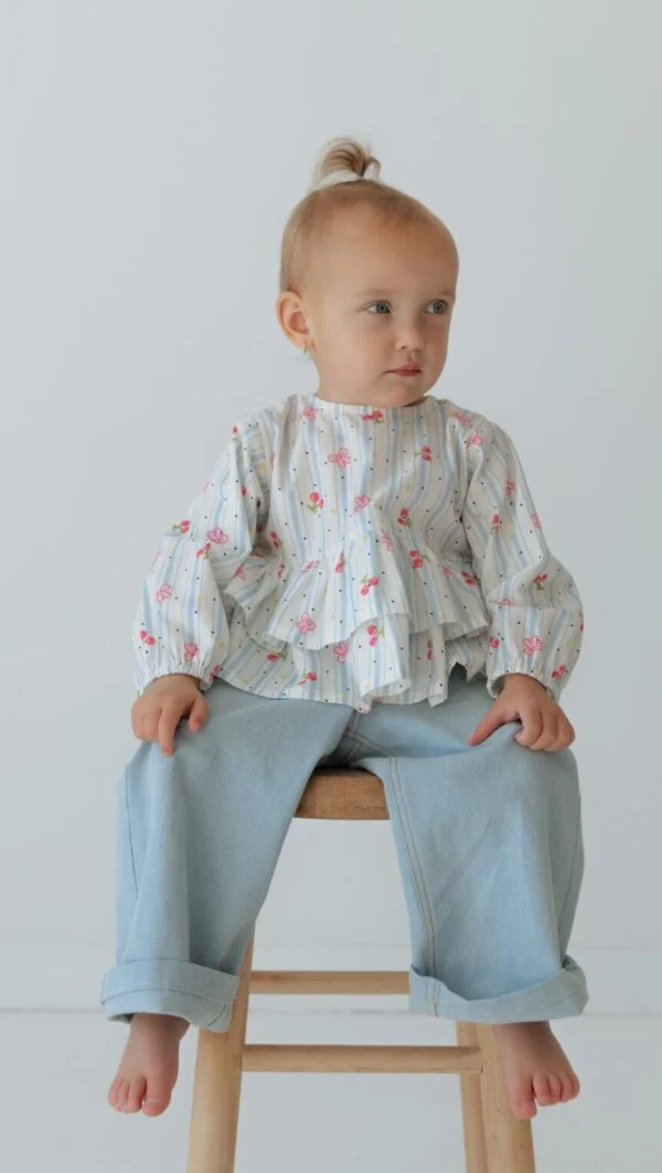 Modern girls blouse sewing pattern featuring long sleeves, ruffle tiers, and oversized unisex jeans