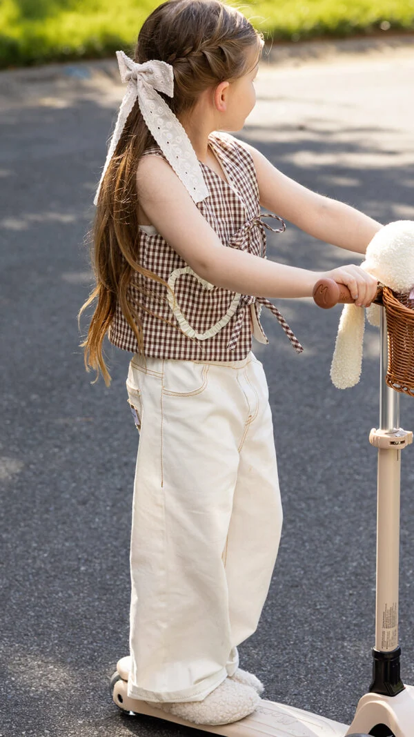 Modern children's vest sewing pattern styled with wide-leg pants and oversized bow ties