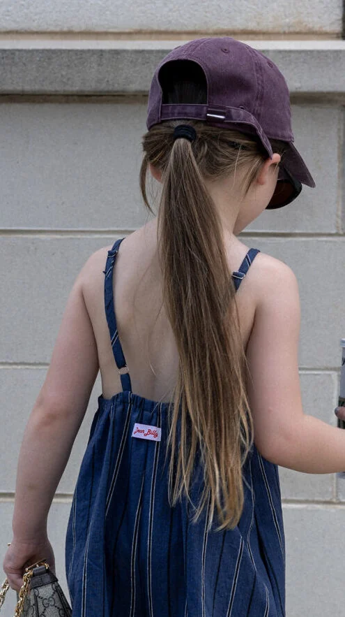 Back view of kids overalls sewing pattern showing adjustable straps with rings and sliders, elasticated back casing, and roomy balloon legs.