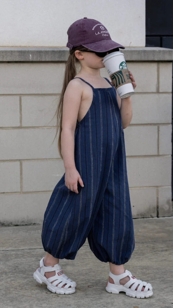 Kids overalls sewing pattern featuring oversized balloon legs, adjustable shoulder straps, elasticated hems, and side pockets in navy pinstripe fabric.